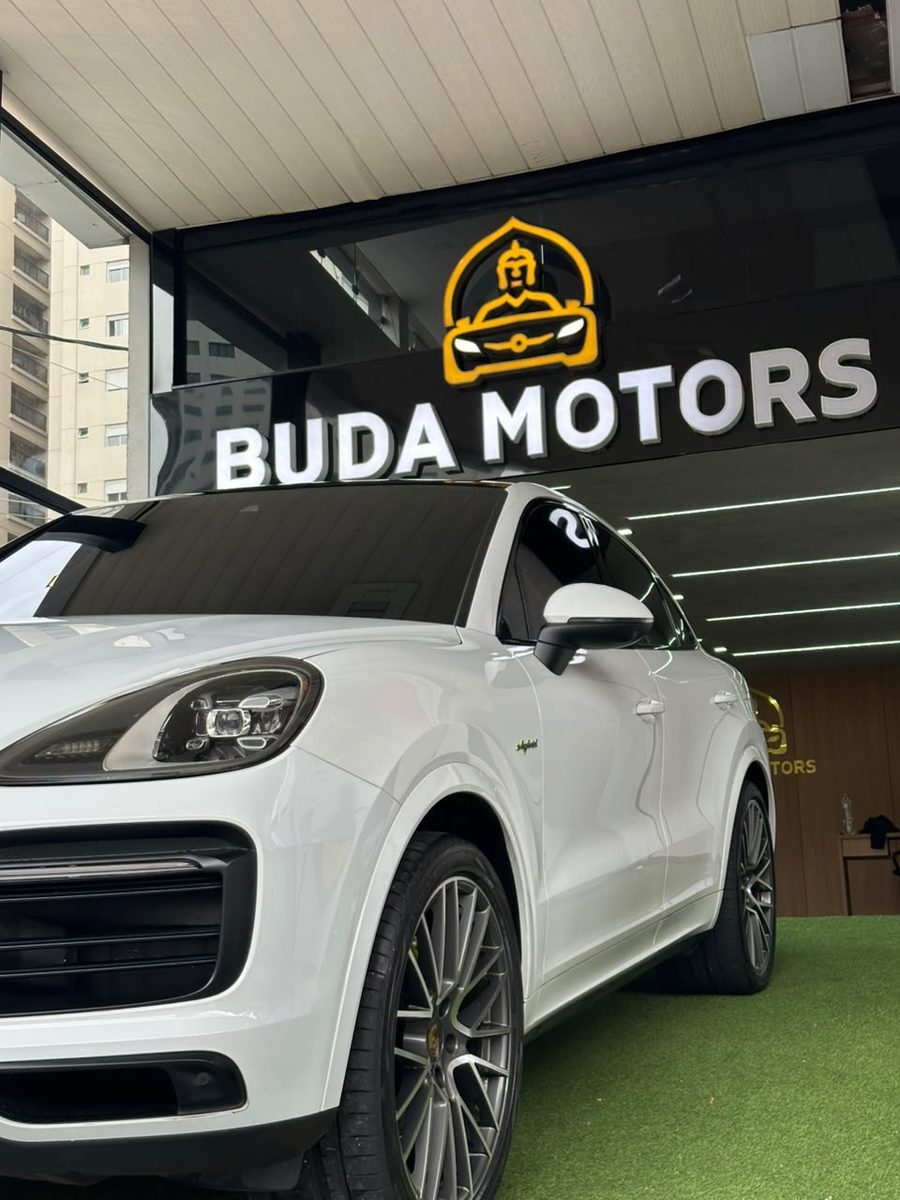 Porsche Cayenne na frente da loja Buda Motors